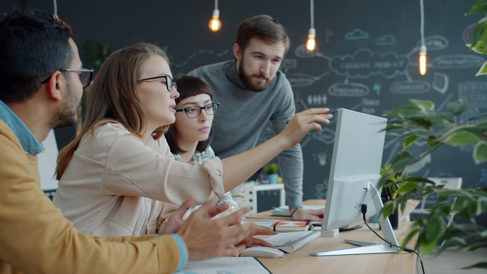 Technology professionals collaborating around a workstation